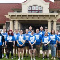 Group of volunteers standing in front of alumni house